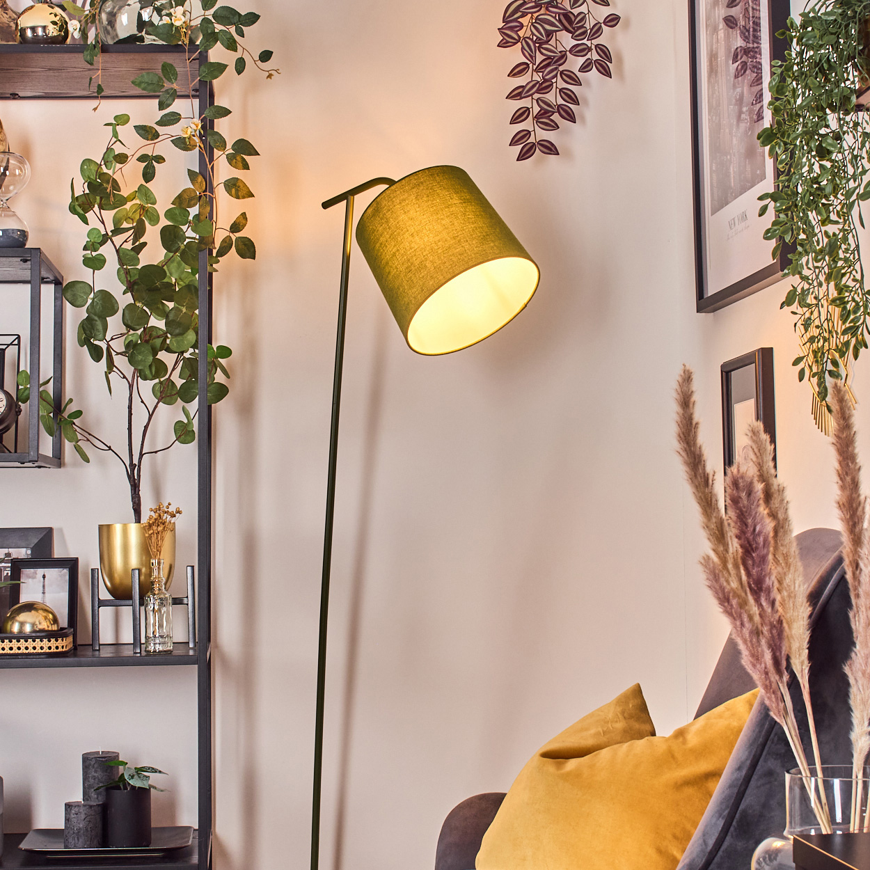 Ein moderner Wohnraum mit einem grünen Stehlampe, Pflanzen und Dekor.