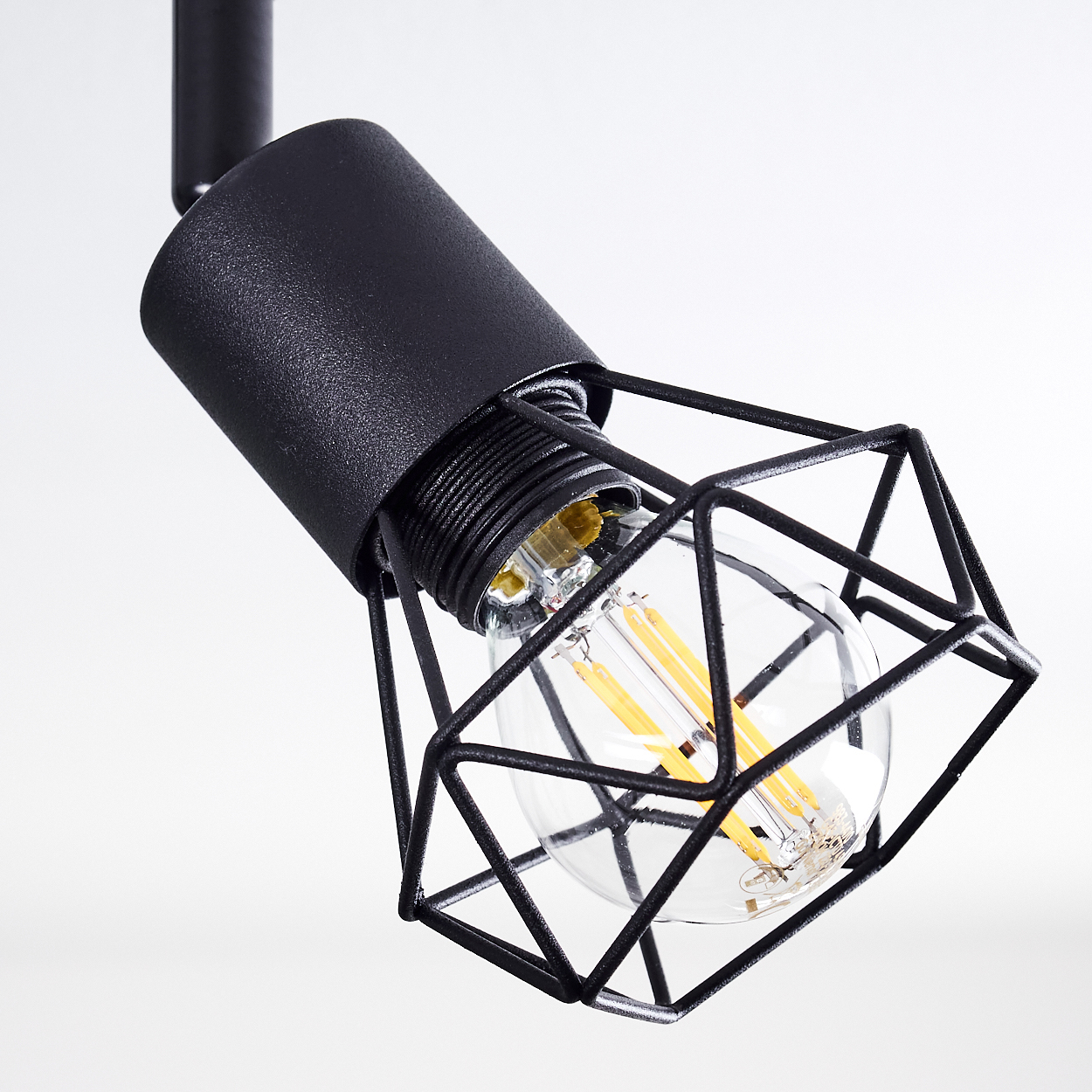 Eine schwarze Pendelleuchte mit Käfig-Design um eine Glühbirne.