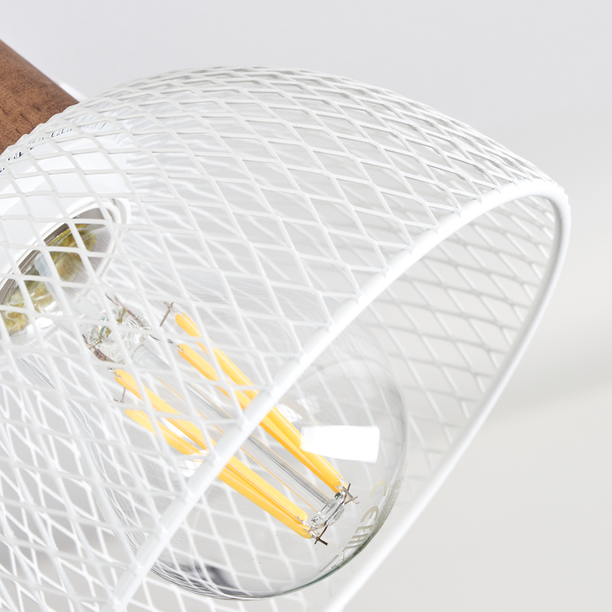Eine weiße Lampe mit einem Holzakzent und einer sichtbaren Glühbirne.