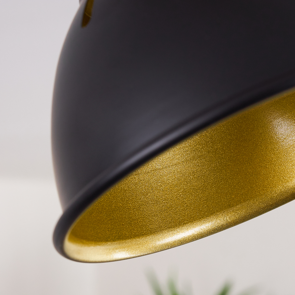 Schwarzer Lampenschirm mit goldener Innenseite, Nahaufnahme.
