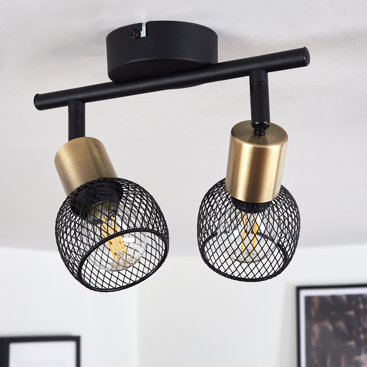 Schwarz-goldene Deckenleuchte mit zwei Lampenschirmen aus Netzmetall.