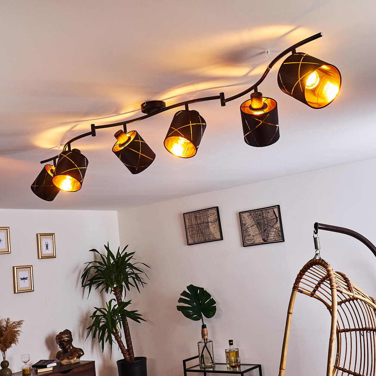 Deckenstrahler mit sechs schwarzen Lampenschirmen mit goldenem Muster.