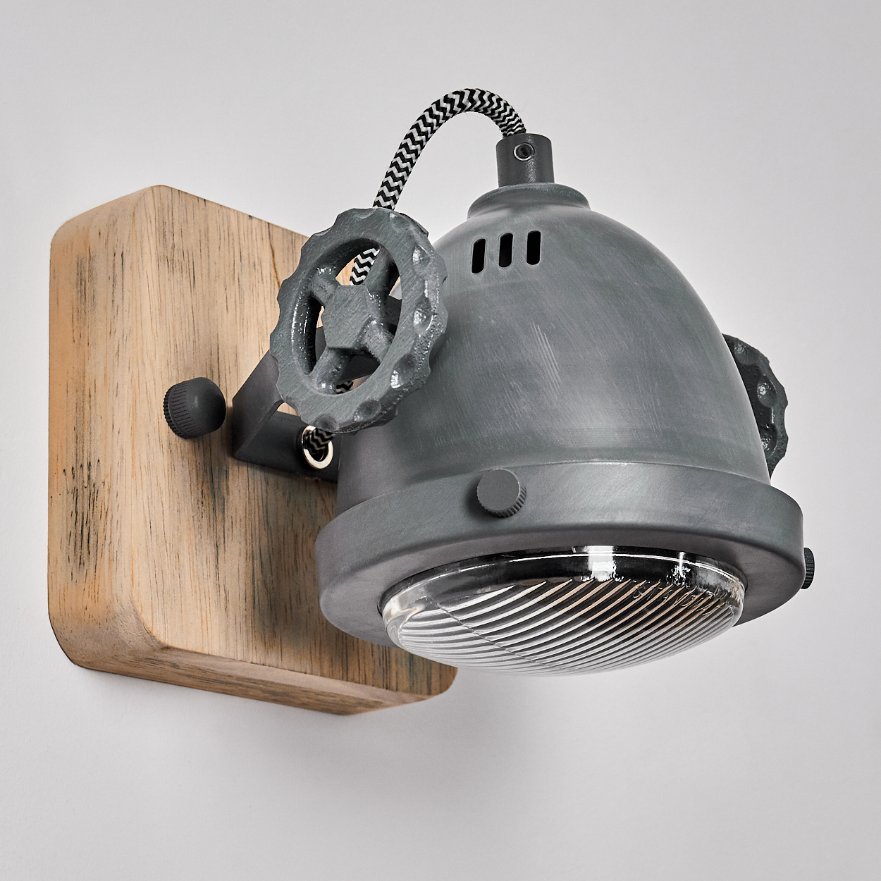 Graue Wandlampe im Industrie-Look auf Holzsockel mit Rändelrad und Glas.