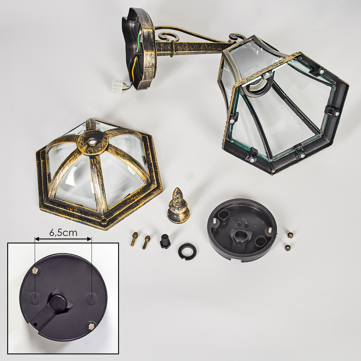 Teile einer goldfarbenen Laterne mit Glas und Befestigungsmaterial auf weißem Grund.