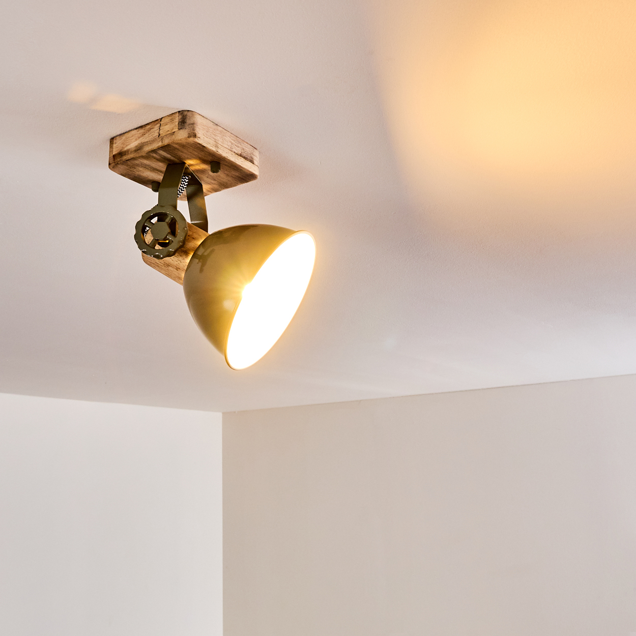 Ein Lampenschirm aus Holz und Metall beleuchtet die Decke.