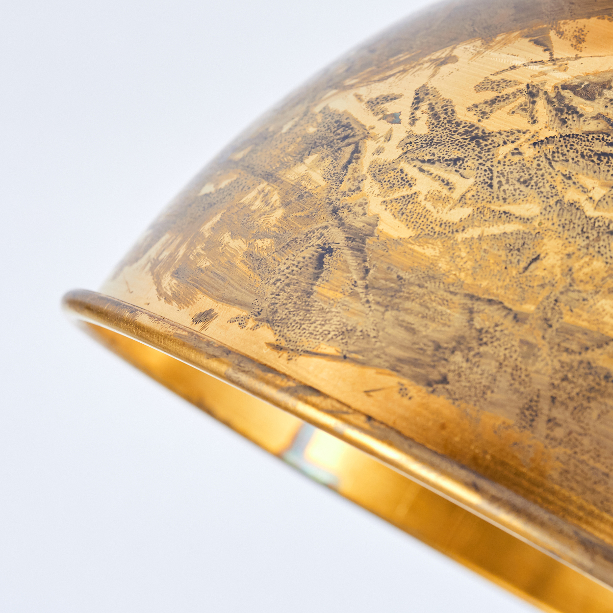 Nahaufnahme einer goldenen Schüssel mit dunklen, gemusterten Akzenten.