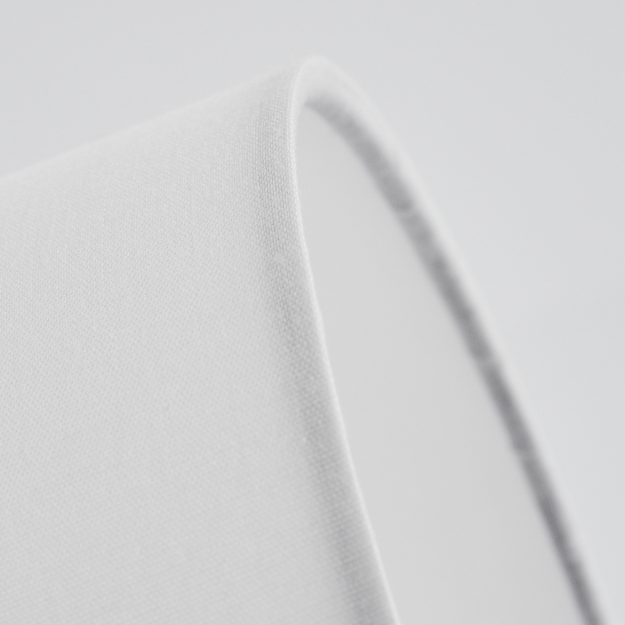 Detailaufnahme von weißem Stoff, der sich krümmt, mit Schatten und Textur.