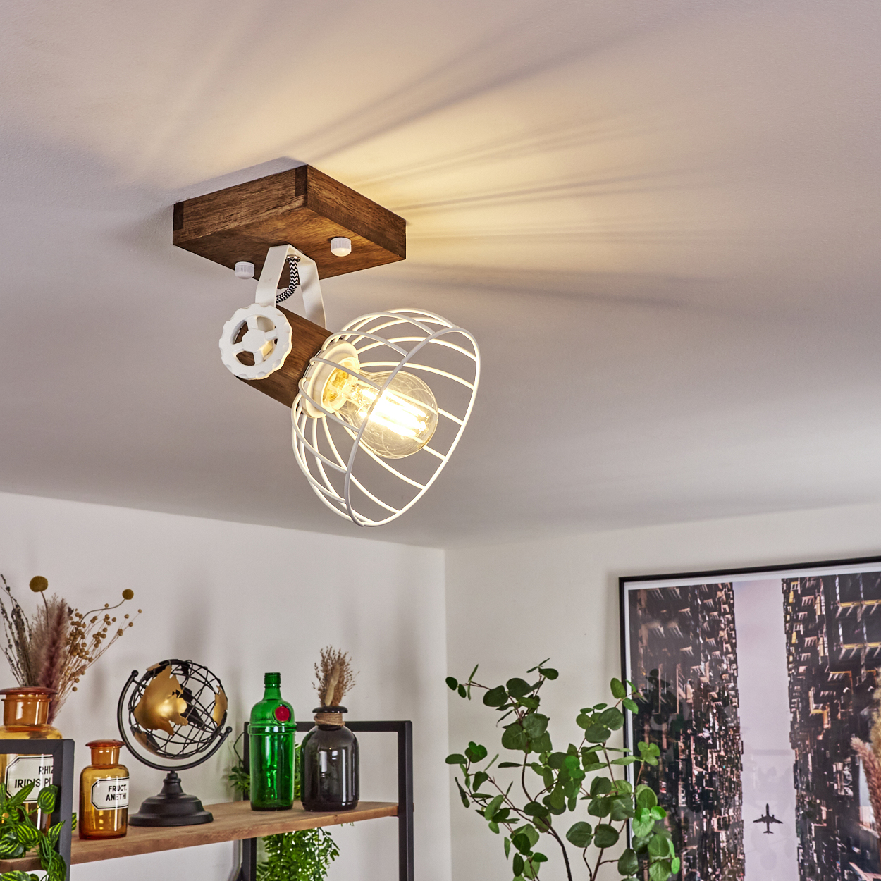 Eine Deckenlampe mit Holzsockel, weißem Käfig und Glühbirne leuchtet.