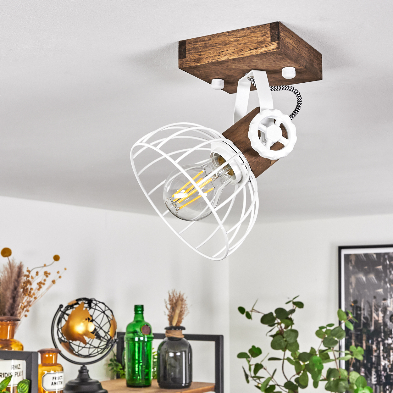 Eine Deckenleuchte mit Holzsockel, weißem Metallkäfig und sichtbarer Glühbirne.