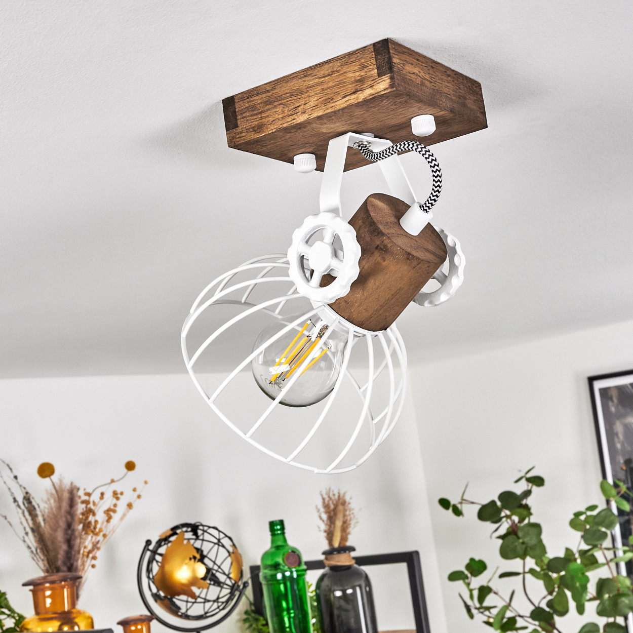 Deckenleuchte mit Holzbalken, weißem Drahtkorb und Glühbirne.