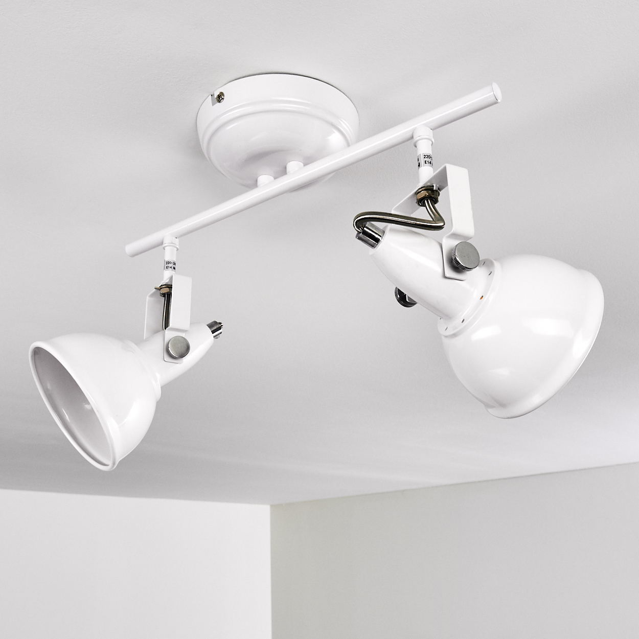 Zwei weiße Deckenstrahler auf einer Stange montiert, die an der Decke befestigt ist.