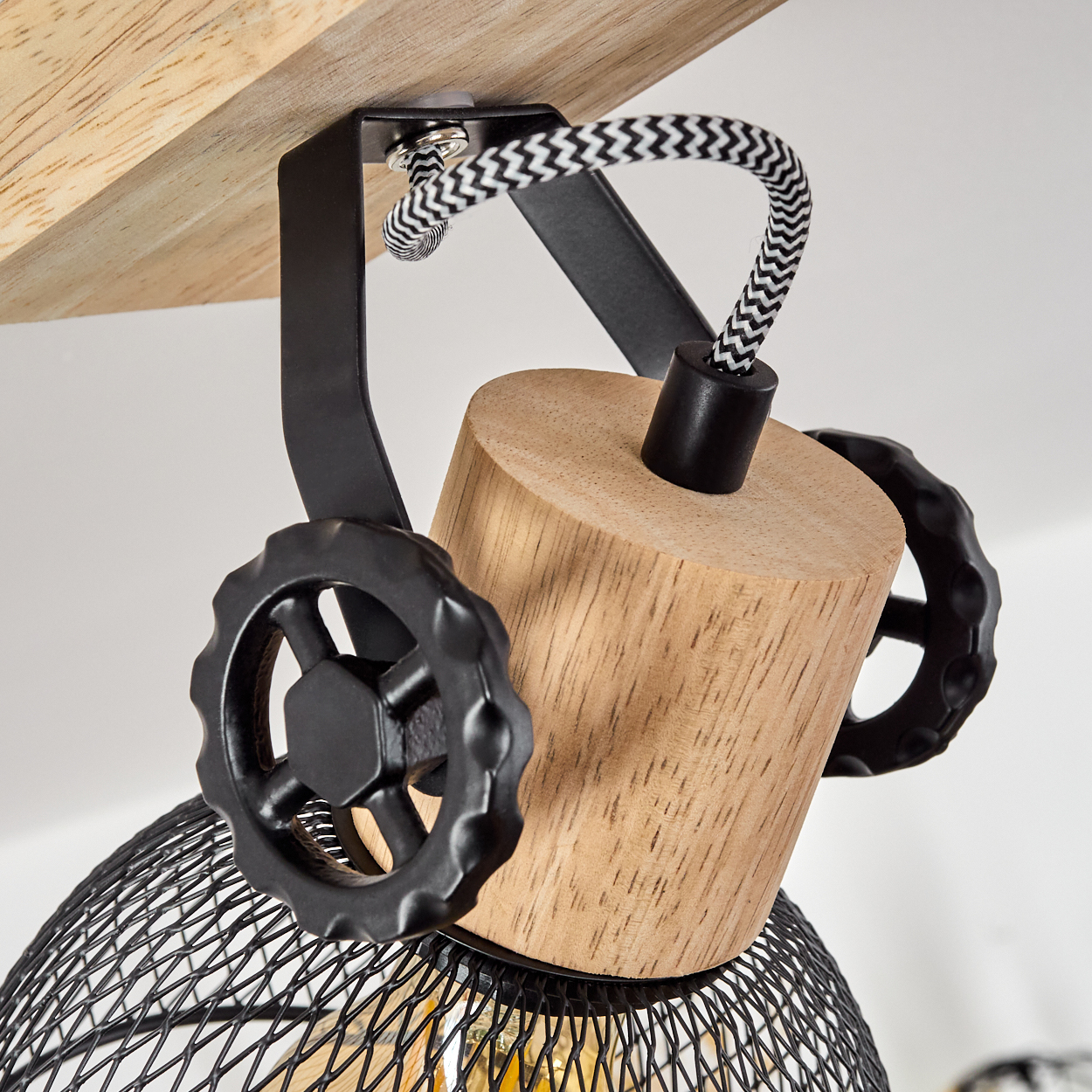 Holz- und Metalllampenaufhängung mit Drahtgeflecht-Schirm und dekorativen Rädern.