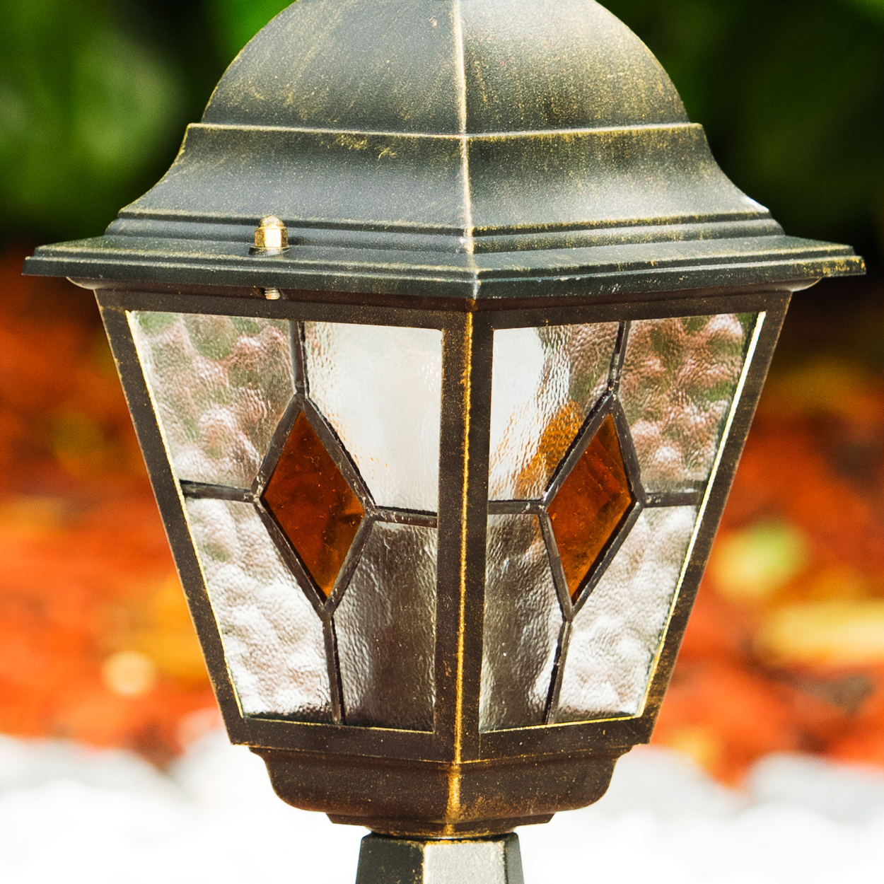 Eine dunkle Lampe mit Glaseinsätzen und bernsteinfarbenen Akzenten.