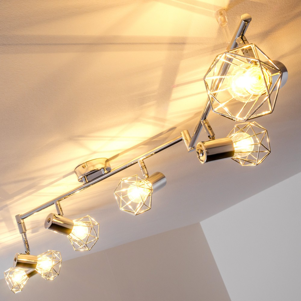 Eine silberne Schienenleuchte mit funf geometrischen Lampenschirmen und Gluhlampen.