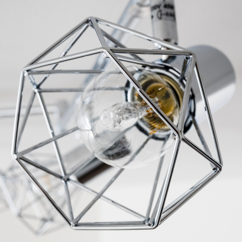 Ein moderner Kronleuchter mit einem geometrischen Metallkäfig und einer Glühbirne.