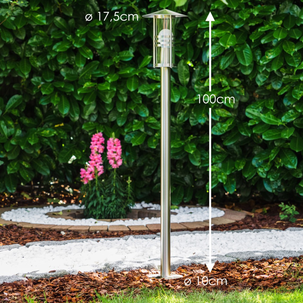 Ein schlanker Edelstahl-Gartenpfosten mit Glaszylinder und Glühbirne.