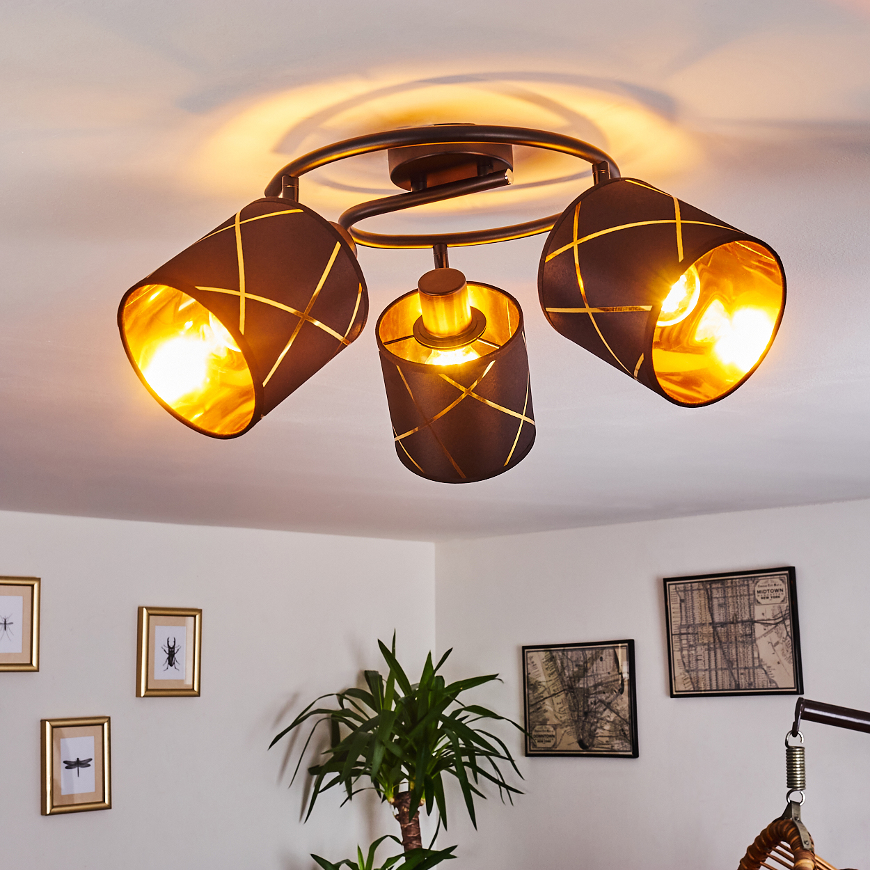 Drei schwarze Lampenschirme mit goldenen Rautenmustern, Deckenleuchte.