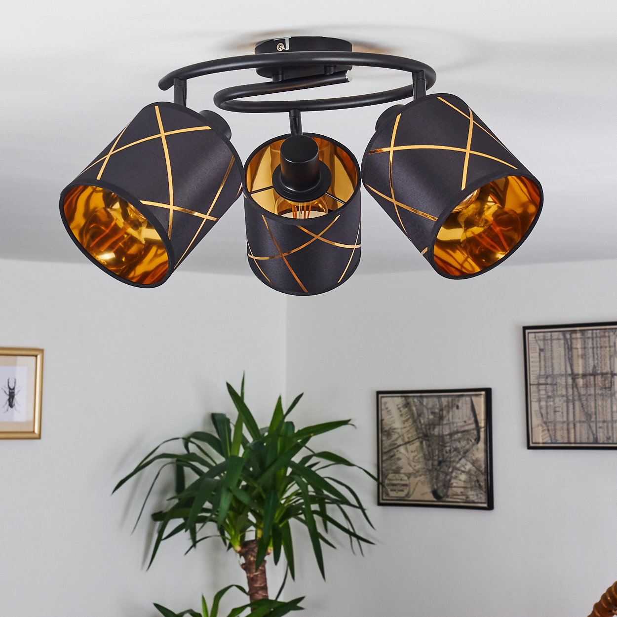 Schwarzer Deckenventilator mit drei Lampenschirmen und Goldakzenten.