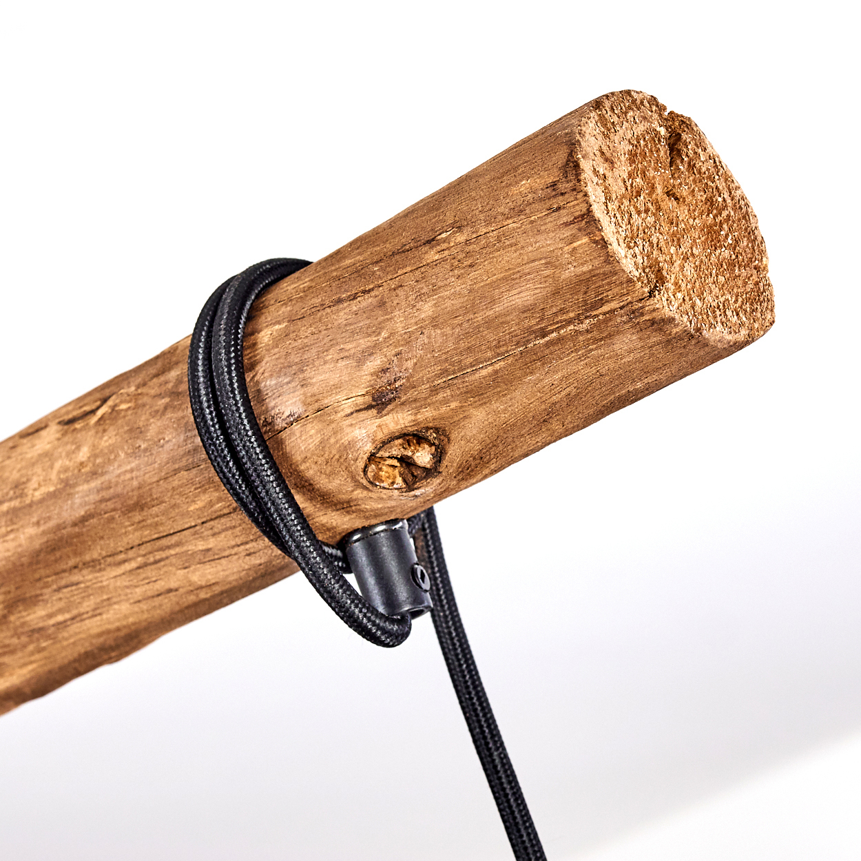 Ein grobes Holzstück mit einem schwarzen Kabel, das darum gewickelt ist.