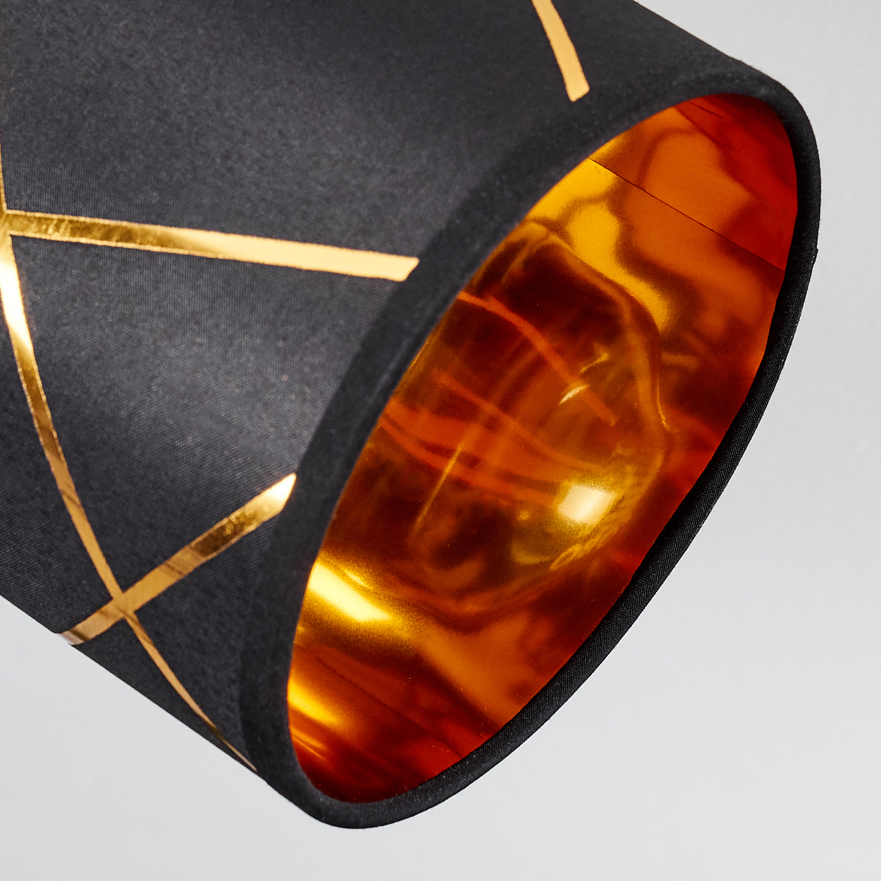 Schwarzer Lampenschirm mit goldenen geometrischen Linien und glänzendem goldenem Inneren.
