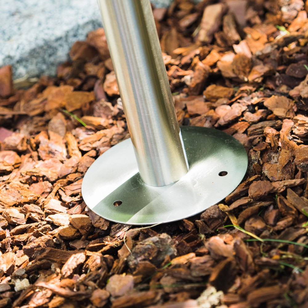 Metallpfosten mit runder Basis auf Rindenmulch und Steinen.