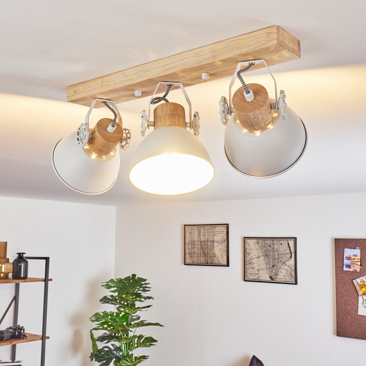 Eine Deckenleuchte mit drei Lampen, weißen Schirmen und Holzakzenten an einer Holzleiste.