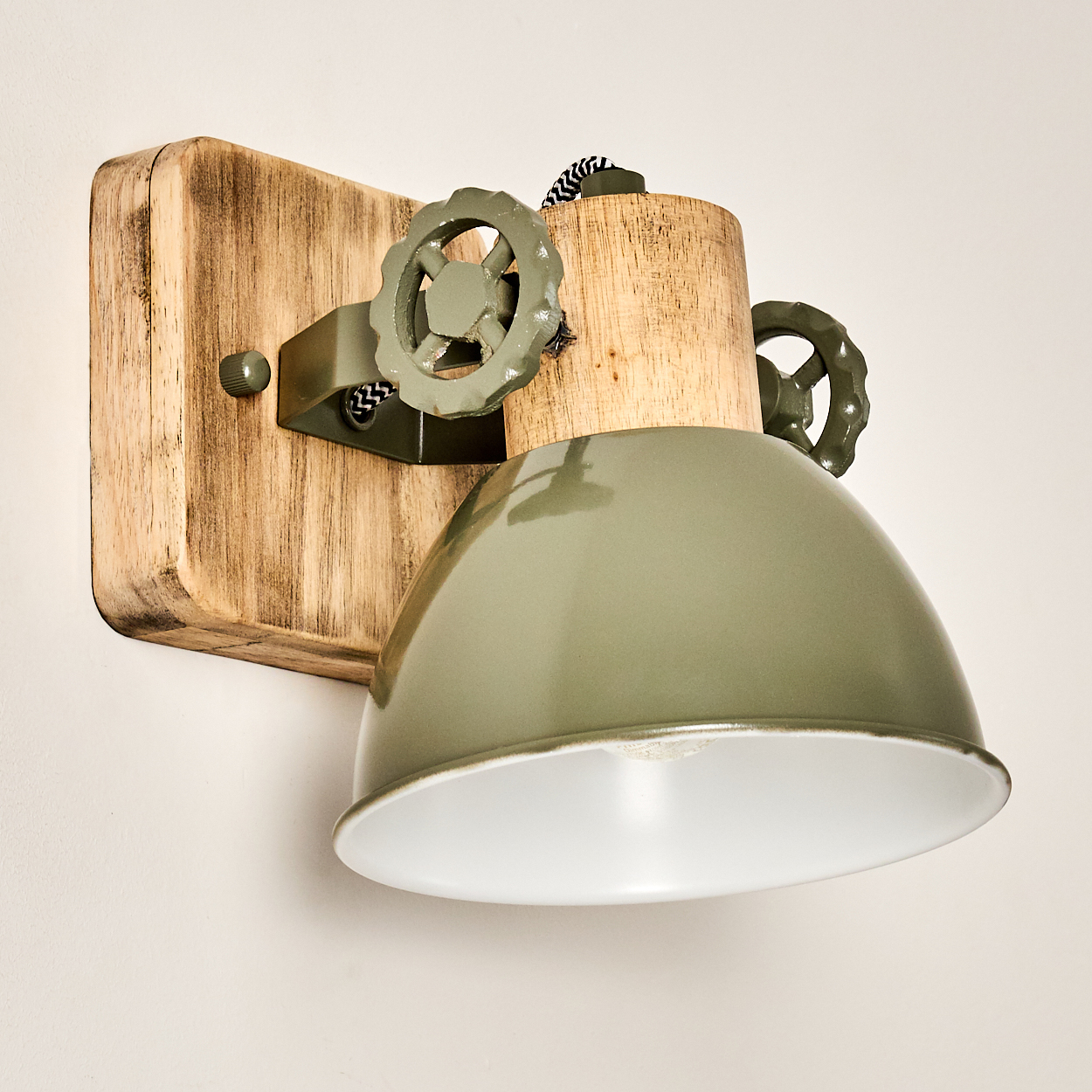 Ein rustikaler Wandleuchter aus Holz mit grünen Metallakzenten und einem Lampenschirm.