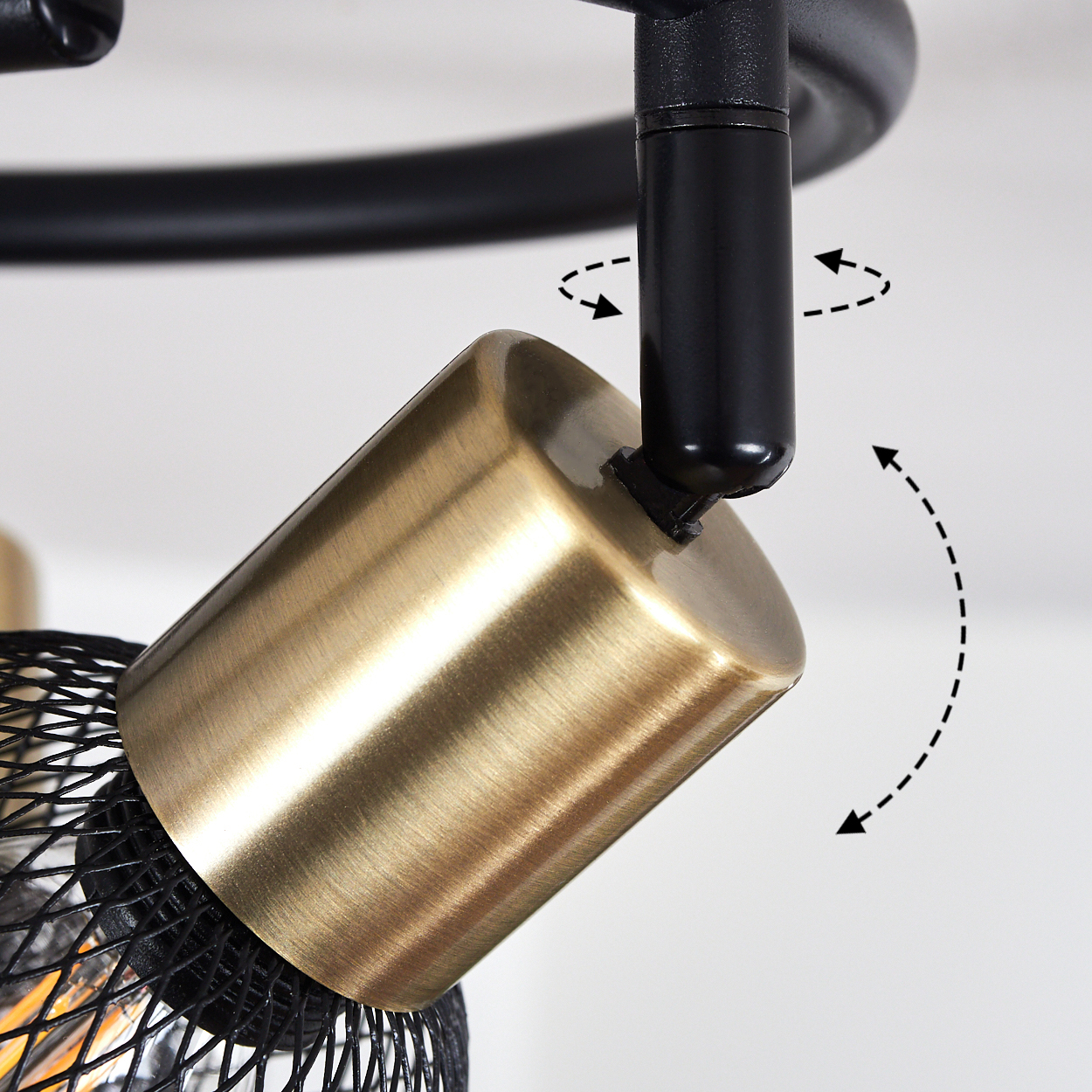 Ein goldener Lampenschirm mit schwarzem Gitter und Pfeilen, die auf Drehungen hinweisen.