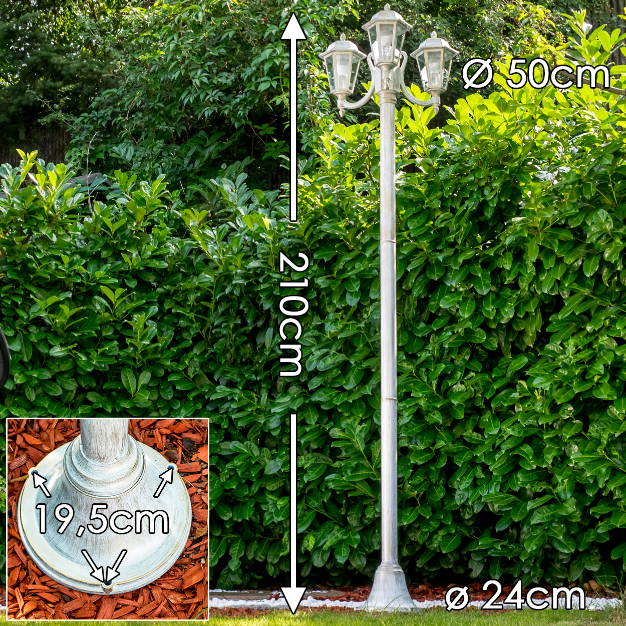 Weiße Laterne, 210cm hoch, mit 3 Lampen, vor einem grünen Busch.
