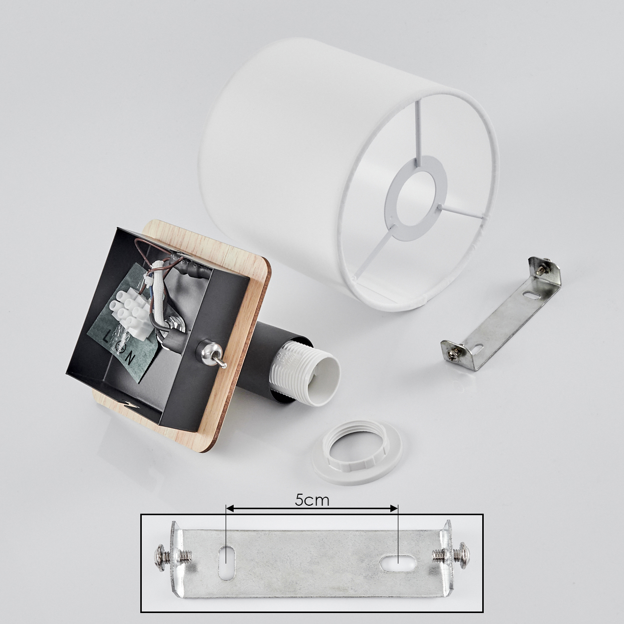 Teile einer weißen Lampe: Lampenschirm, Holzbefestigung, Metallbügel und Messung.