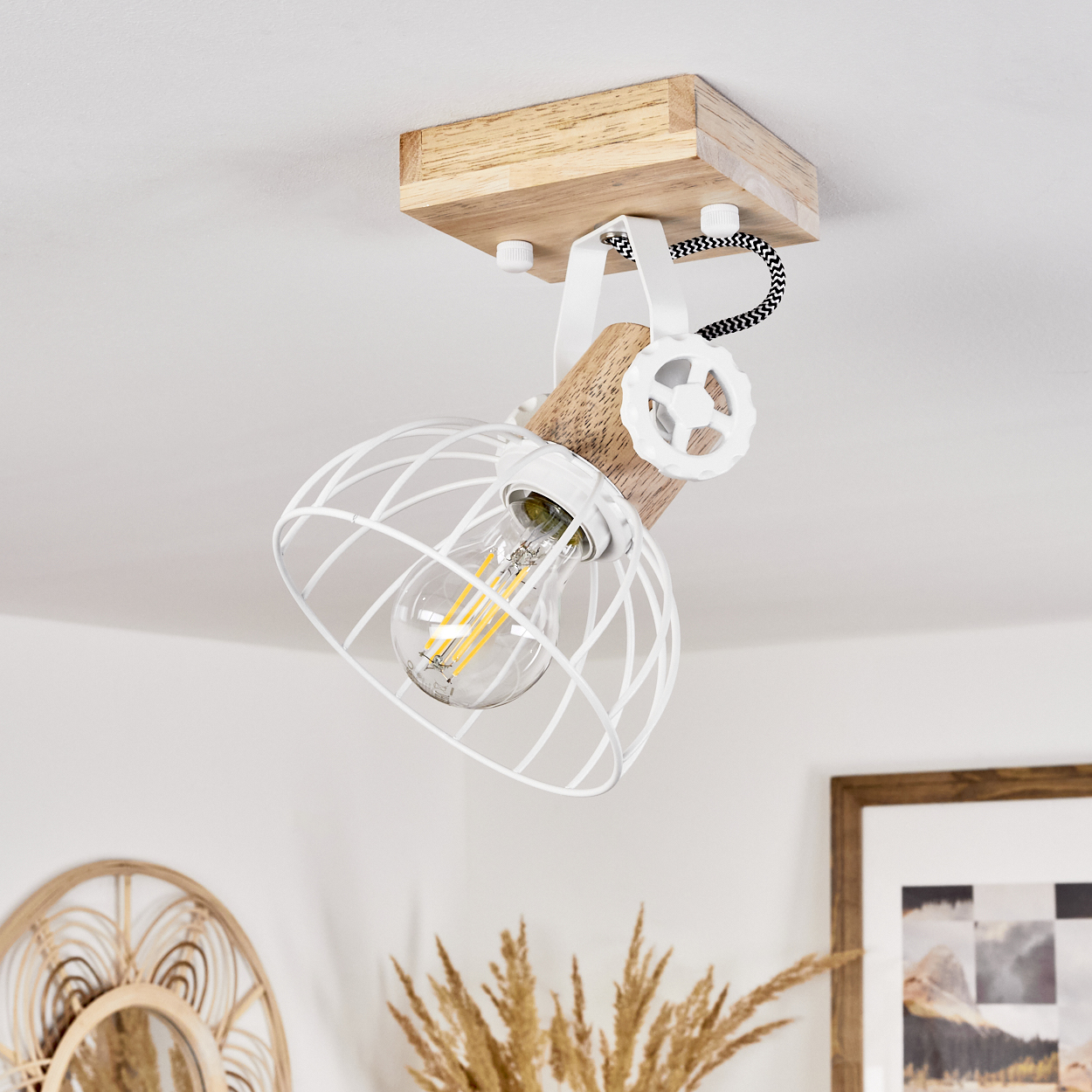 Eine weiße Drahtkorblampe mit Holzdetails und sichtbarem Leuchtmittel.