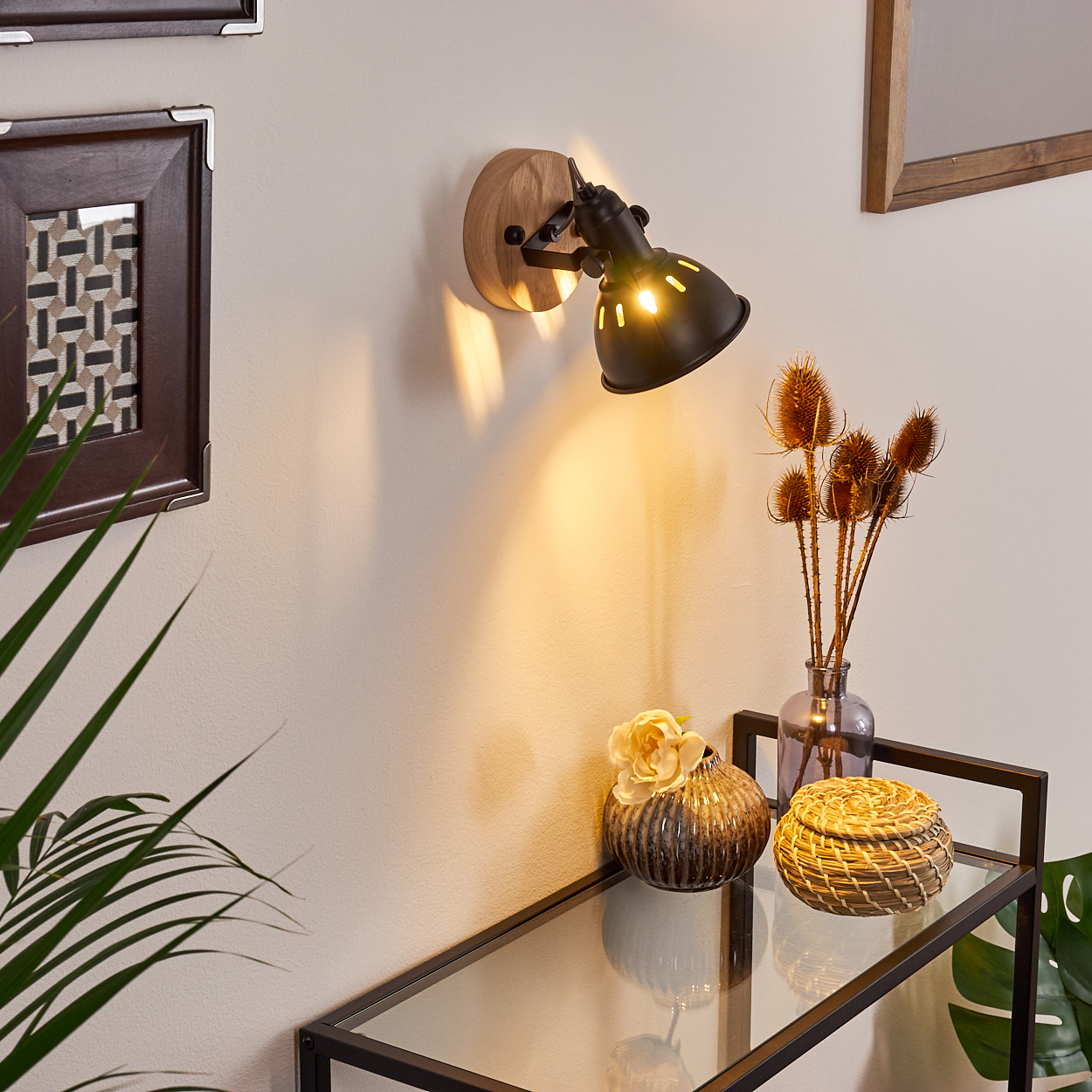 Ein Wandstrahler beleuchtet eine Wand mit Dekorationen.