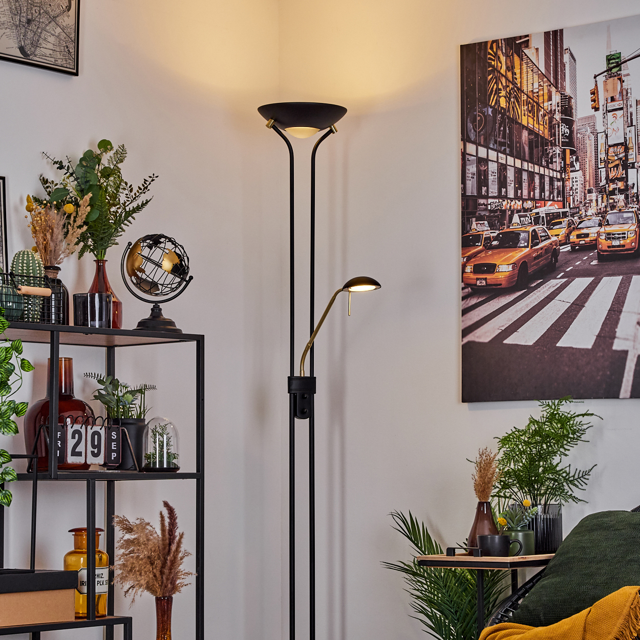 Ein moderner Stehlampe neben einem Regal mit Pflanzen und Deko.