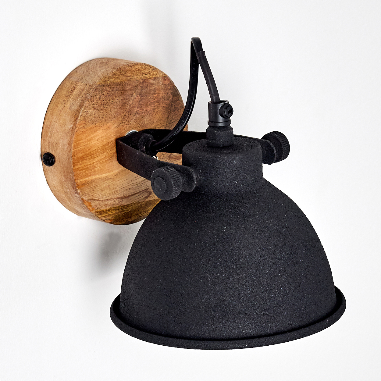 Eine schwarze Wandleuchte mit Holzsockel und verstellbarem Arm.