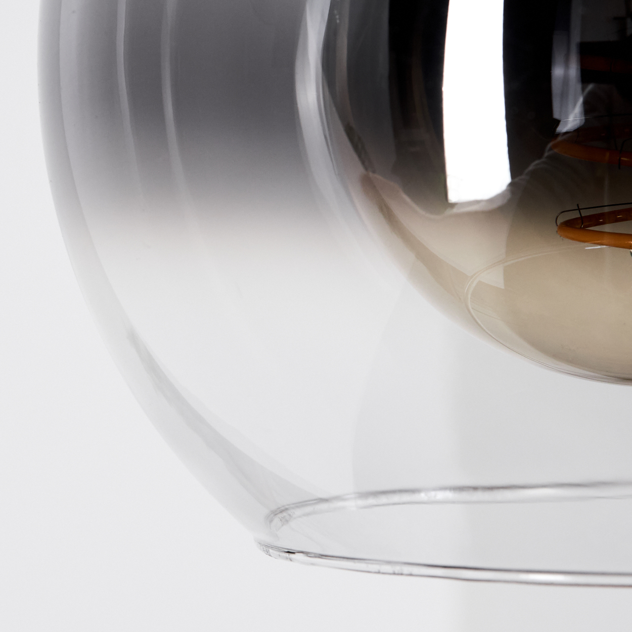 Eine Glühbirne mit einem sichtbaren Heizdraht im Inneren, umgeben von klarem Glas.