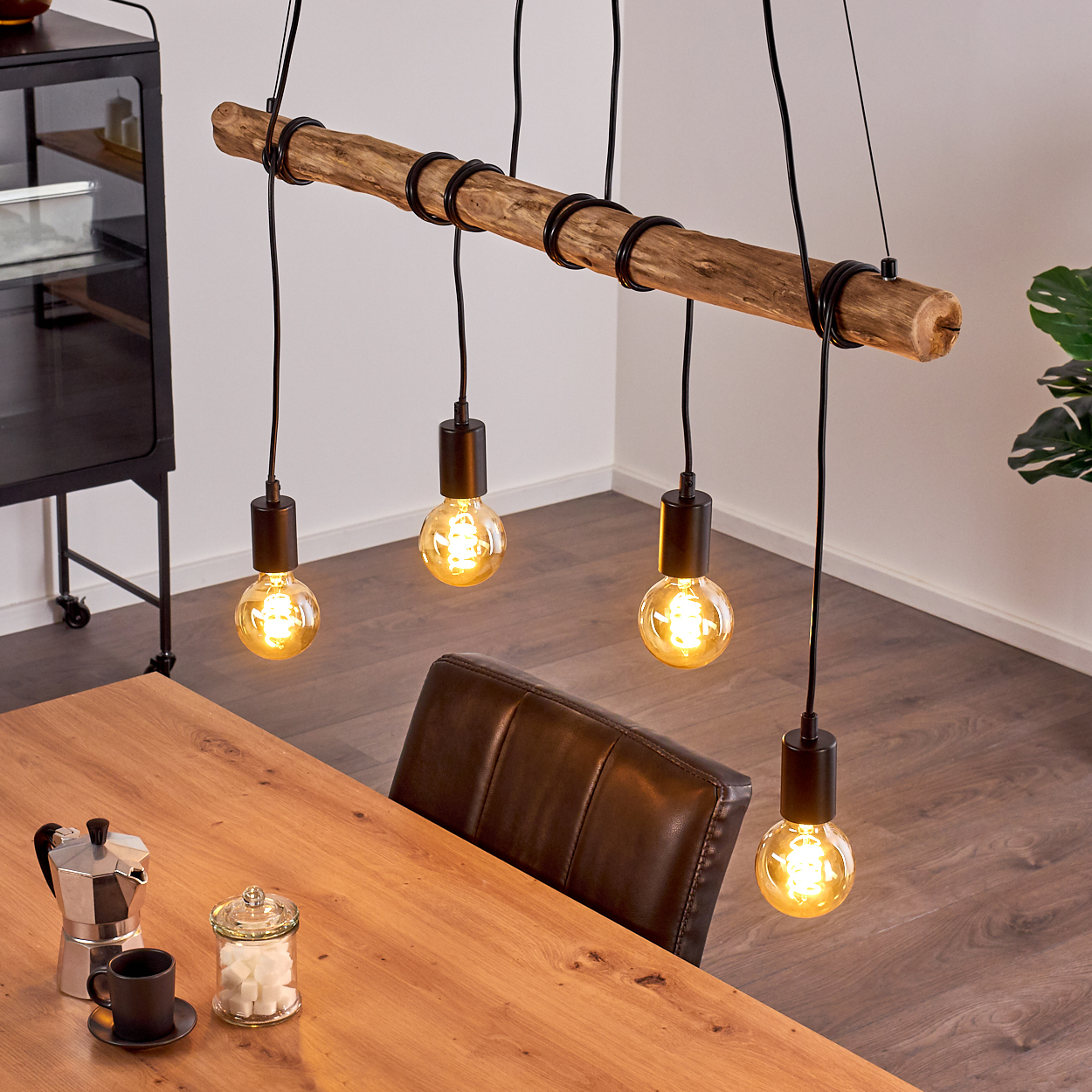 Hängelampe aus Holz mit vier Edison-Glühbirnen über einem Holztisch.