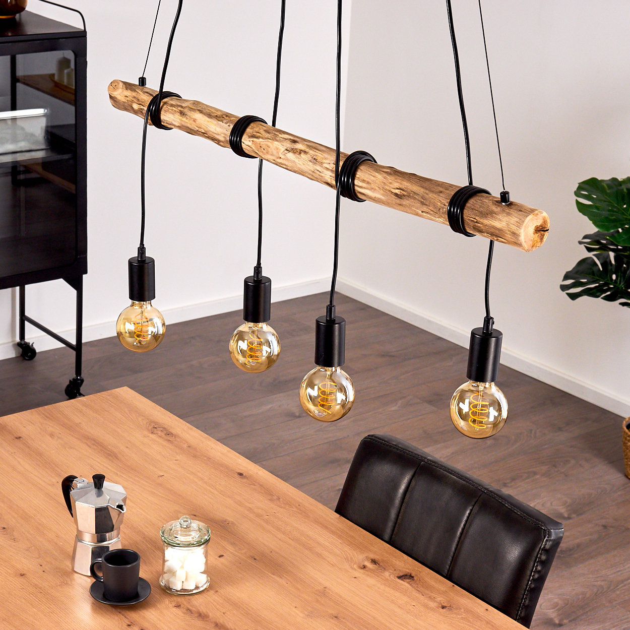 Holzbalken-Hängelampe mit vier Edison-Glühbirnen über Holztisch.