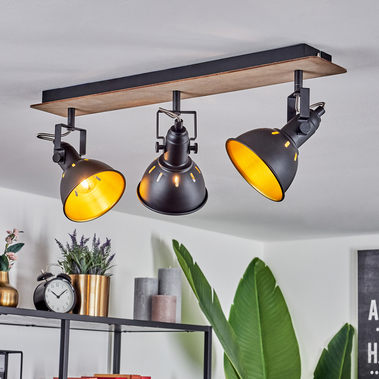 Schwarzer Deckenstrahler mit Holzbasis und drei verstellbaren Lampen.