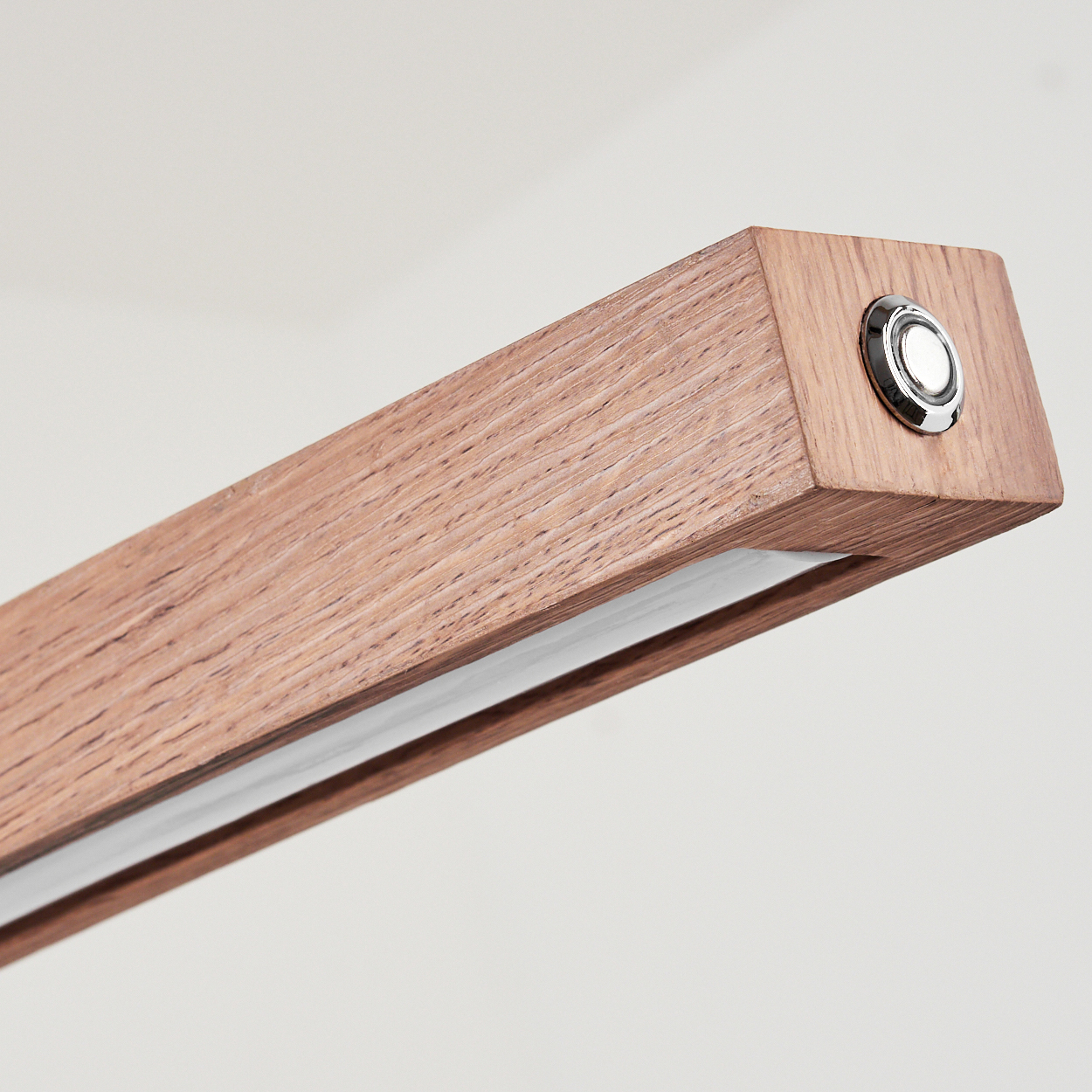 Ein hölzerner Lampenkörper mit einem silbernen Knopf an einem Ende.