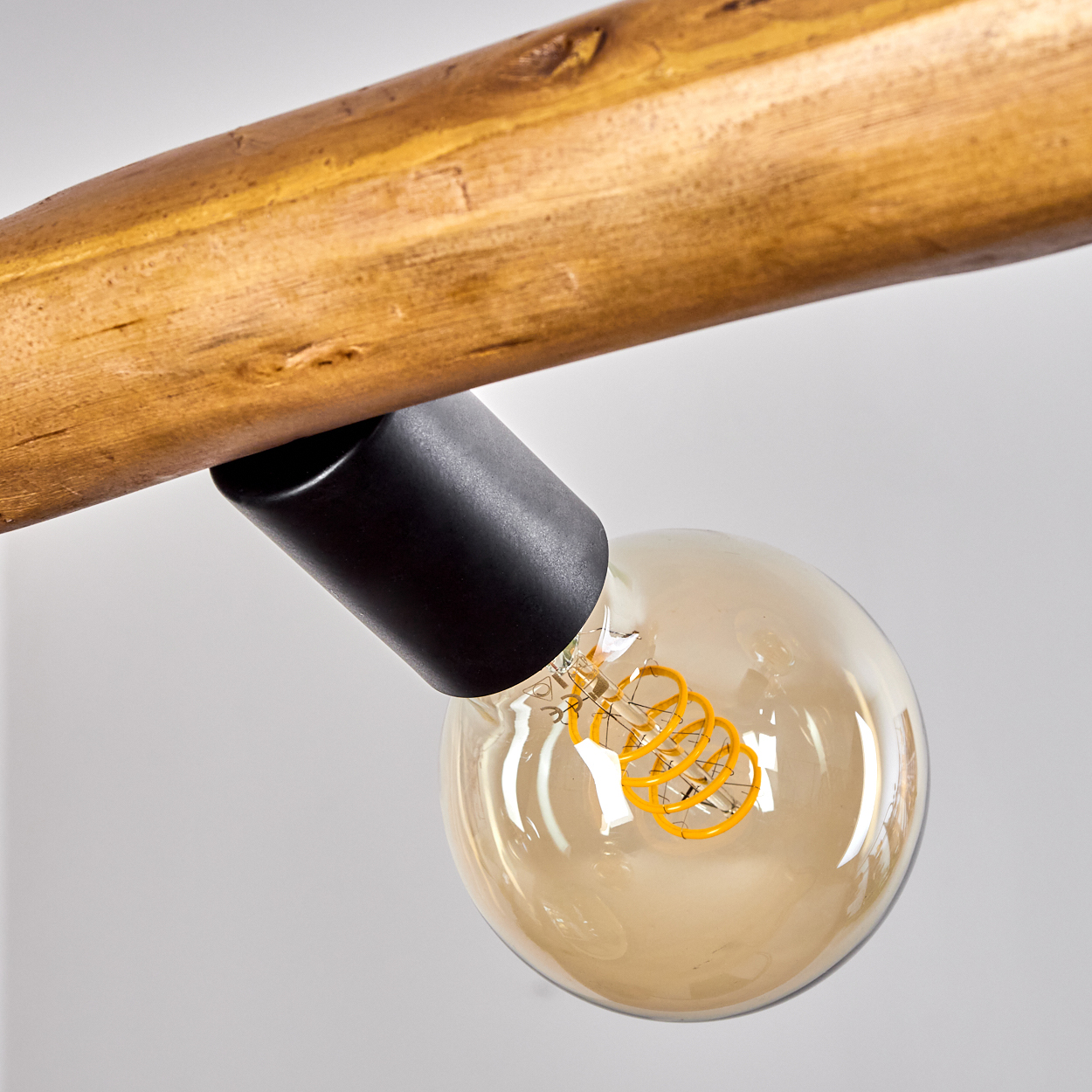 Holzstange mit schwarzem Lampenhalter und Edison-Glühbirne.
