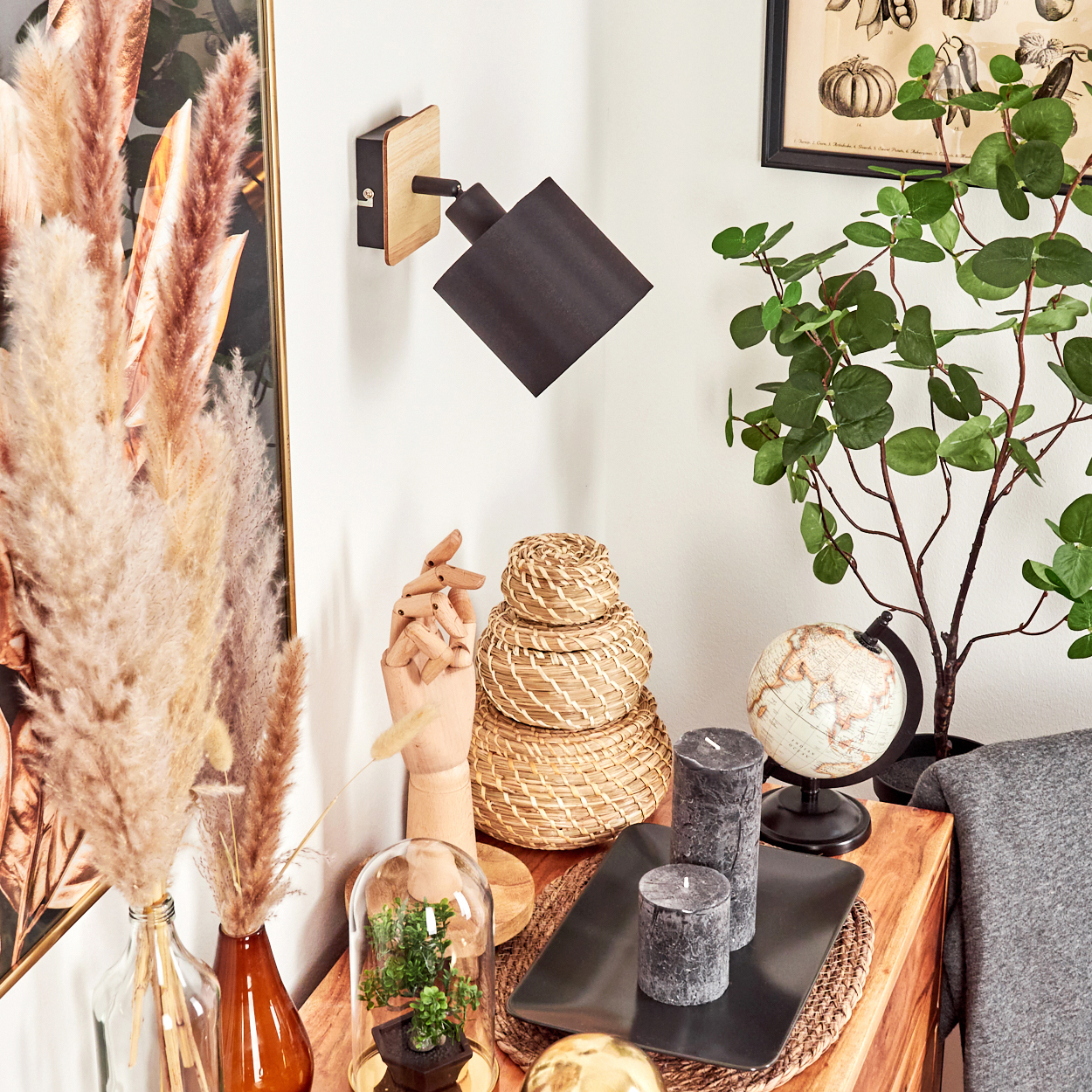 Holzregal mit Deko: Lampe, Pflanzen, Kerzen, Globus.