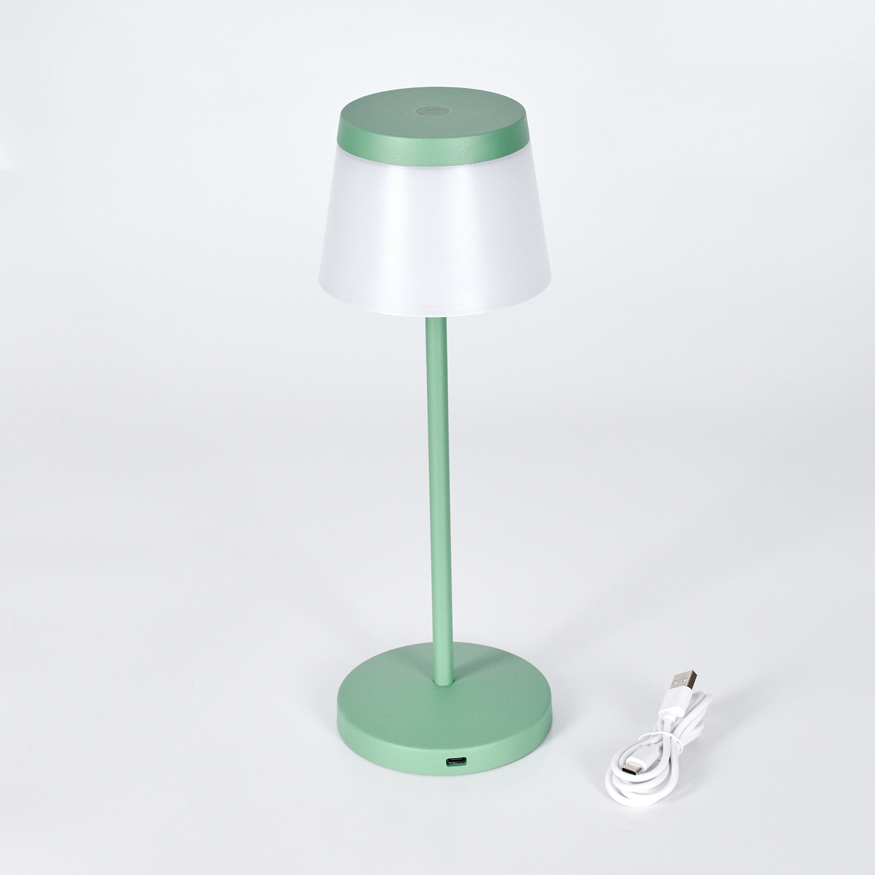 Eine grüne moderne Schreibtischlampe mit weißem Schirm und USB-Ladekabel.