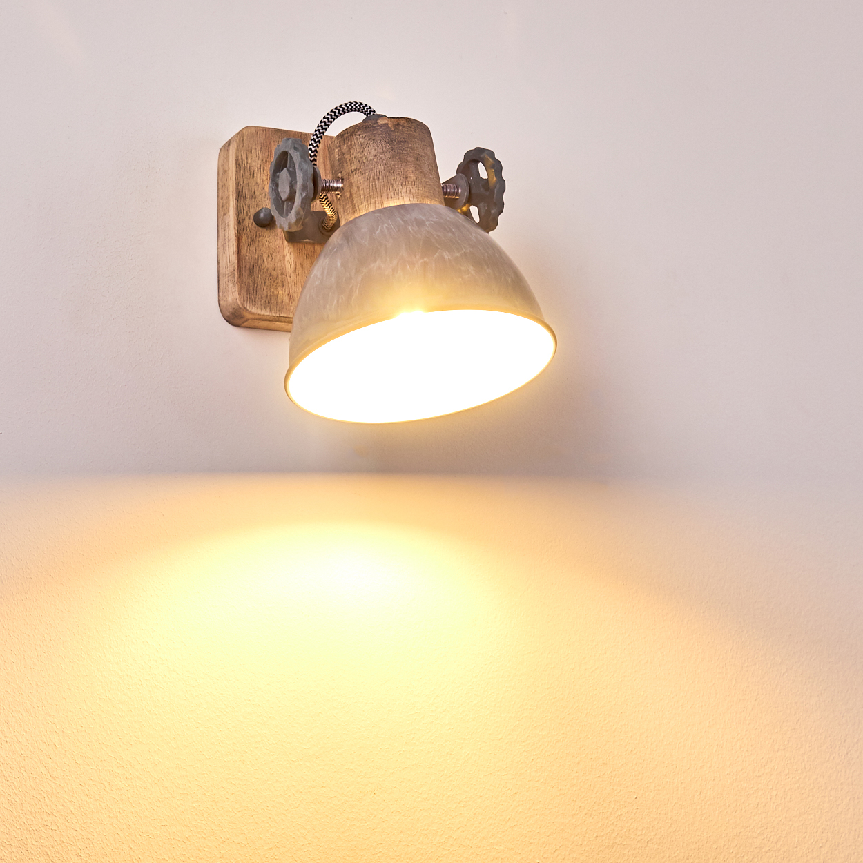 Ein Wandleuchte mit Holzsockel, Metallschirm und Drehknöpfen.