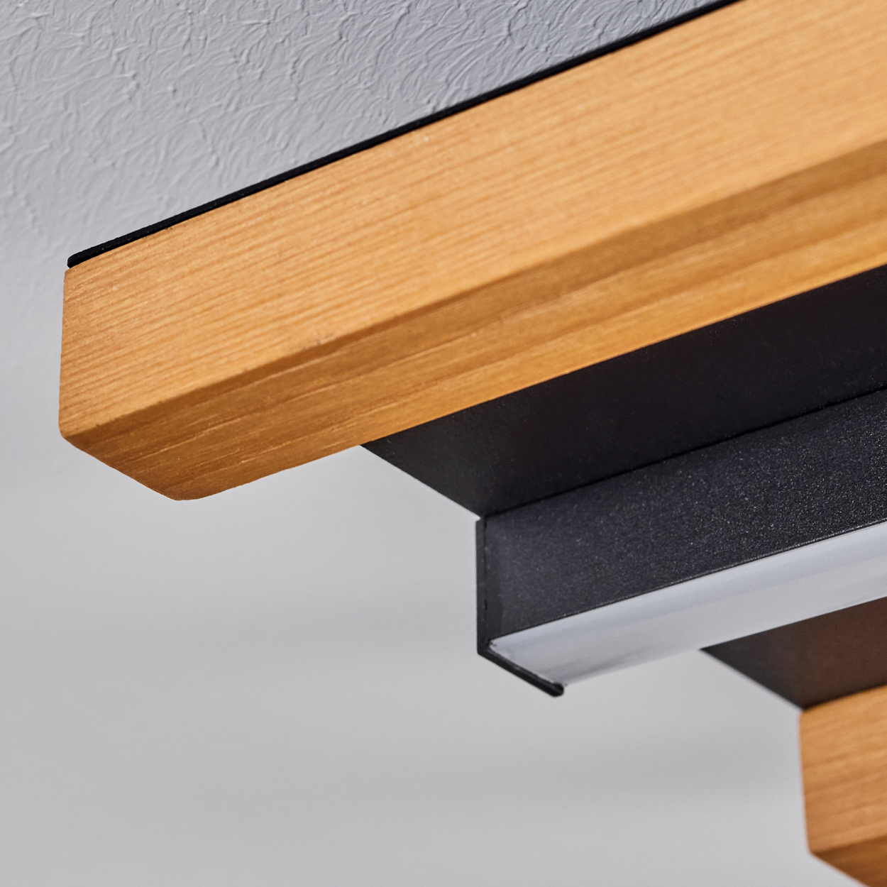 Holzdekor-Leuchte mit schwarzem Metall und LED-Lichtleiste an einer Decke.