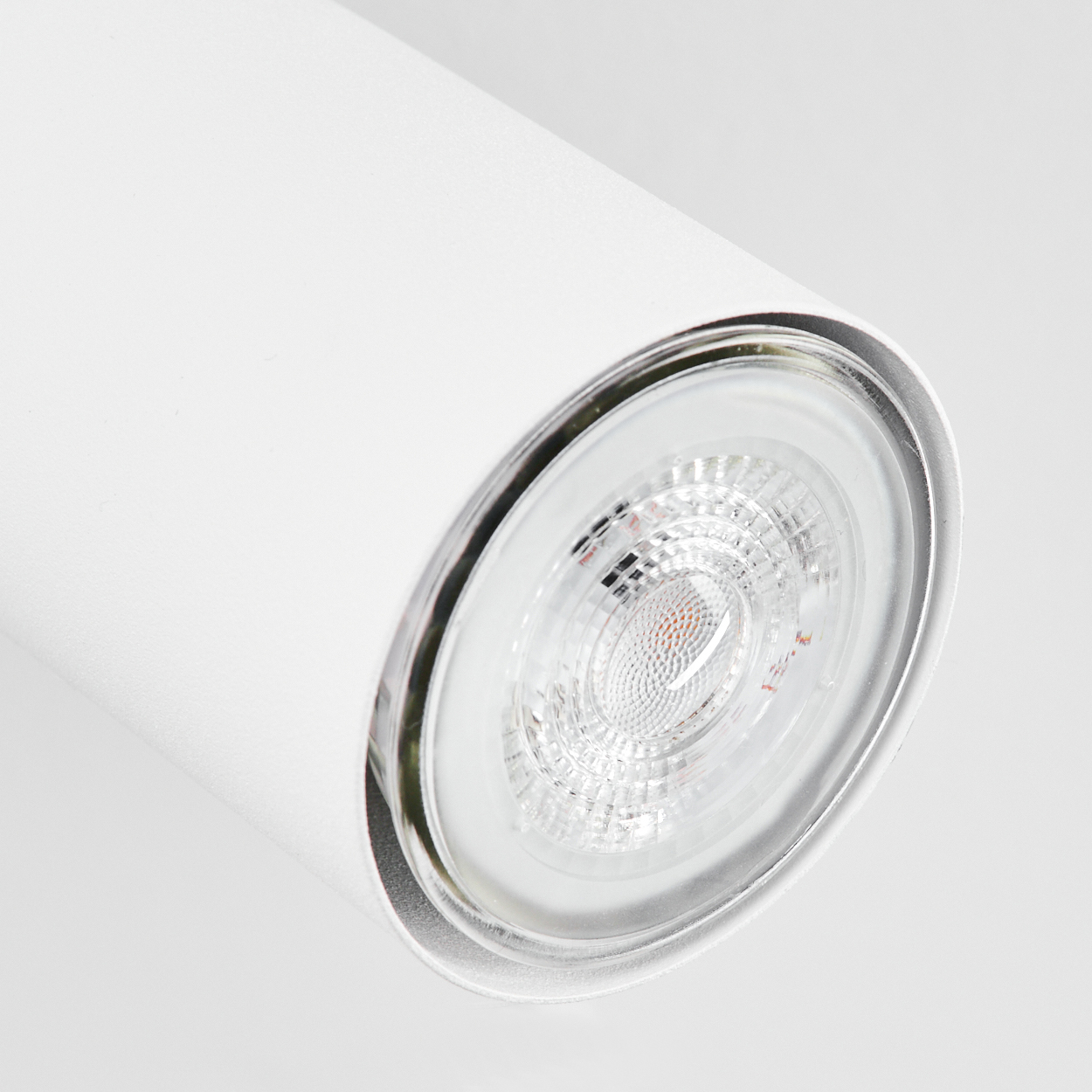 Eine weiße zylindrische Lampe mit einem durchsichtigen Lampenschirm und sichtbaren LEDs.