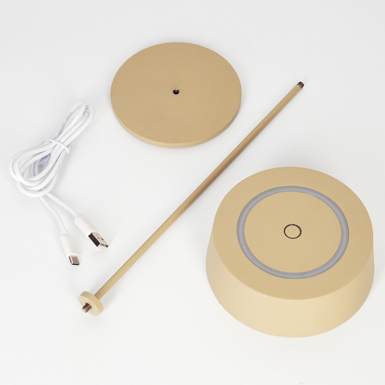 Ein goldener Lampenfuß, Stange, runde Basis und USB-Kabel liegen auf weißem Grund.