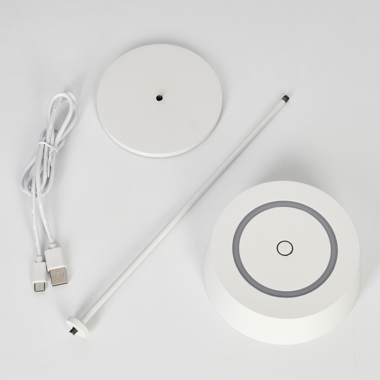 Weiße Lampenbasis, Stab, Kabel und runde Basis auf weißem Hintergrund.