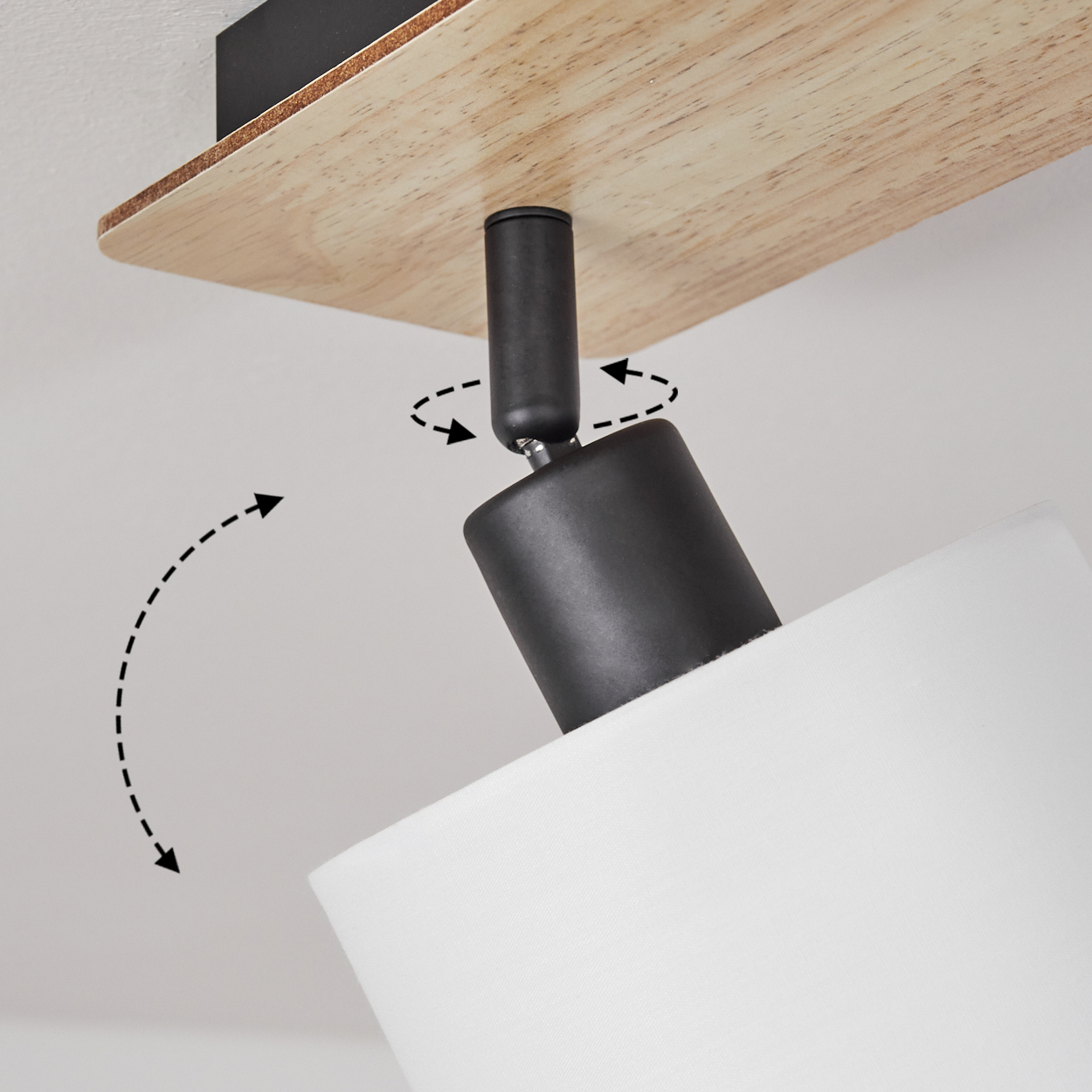 Ein schwenkbarer schwarzer Lampenschirm mit weißem Stoff an einer Holzdecke.