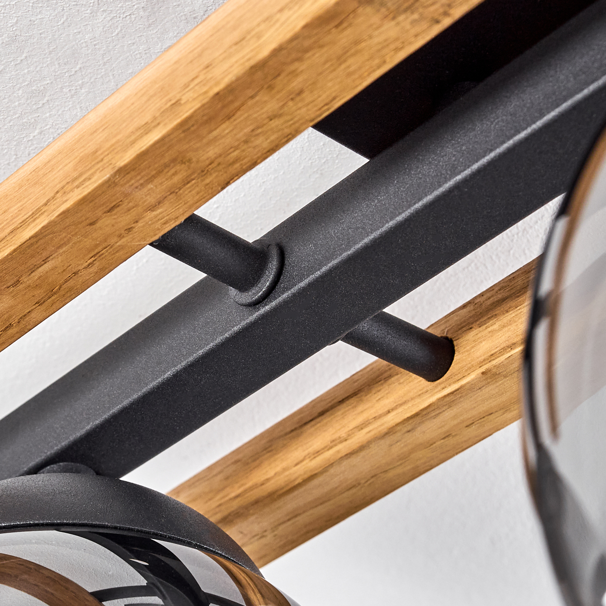 Holz- und schwarze Metallstreben mit Glaslampenschirmen, Nahaufnahme.