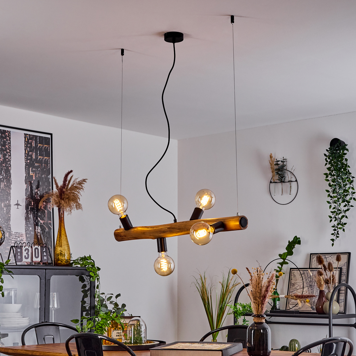 Ein Kronleuchter aus Holzbalken mit fünf Edison-Glühbirnen hängt über einem Esstisch.